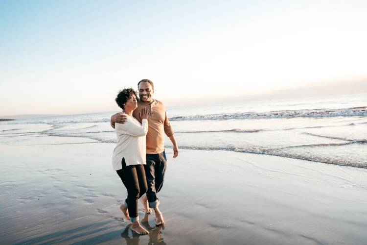 Couple Walking Together On Beach In California